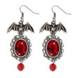 Bat Earrings with Red Gems — A pair of metal bats with wings spread, each set with a small red faceted stone.