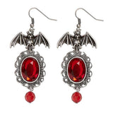 Bat Earrings with Red Gems — A pair of metal bats with wings spread, each set with a small red faceted stone.