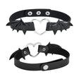 Winged Heart Choker — A black faux-leather choker band with a small heart pendant framed by a pair of bat wings.
